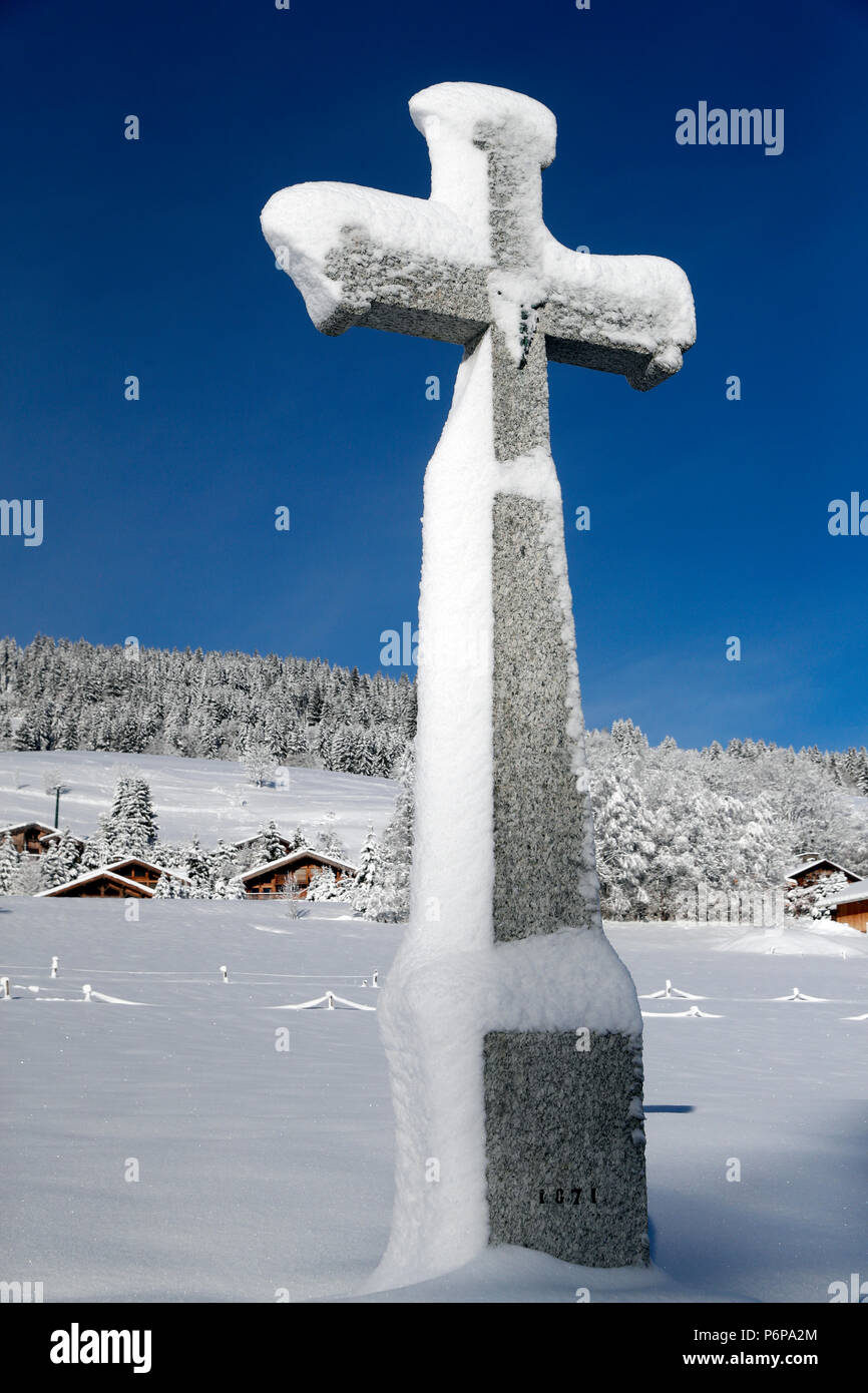 Kreuz aus Stein mit Schnee im Winter. Megeve. Frankreich. Stockfoto