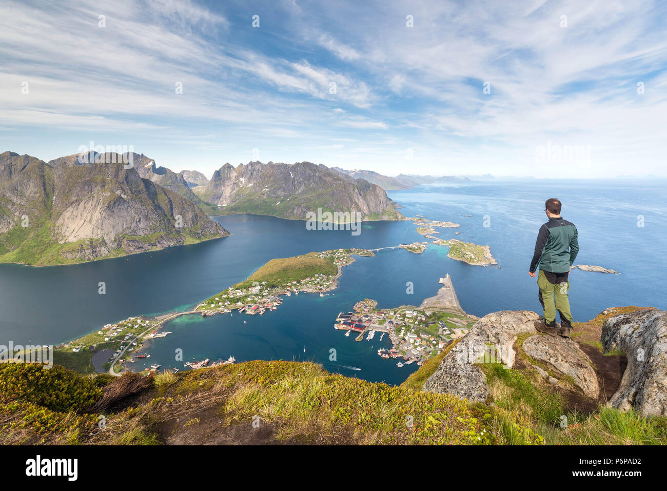 Der Mensch auf dem Gipfel des Reinebringen, Dorf unten ist Reine, Norland, Norwegen Stockfoto