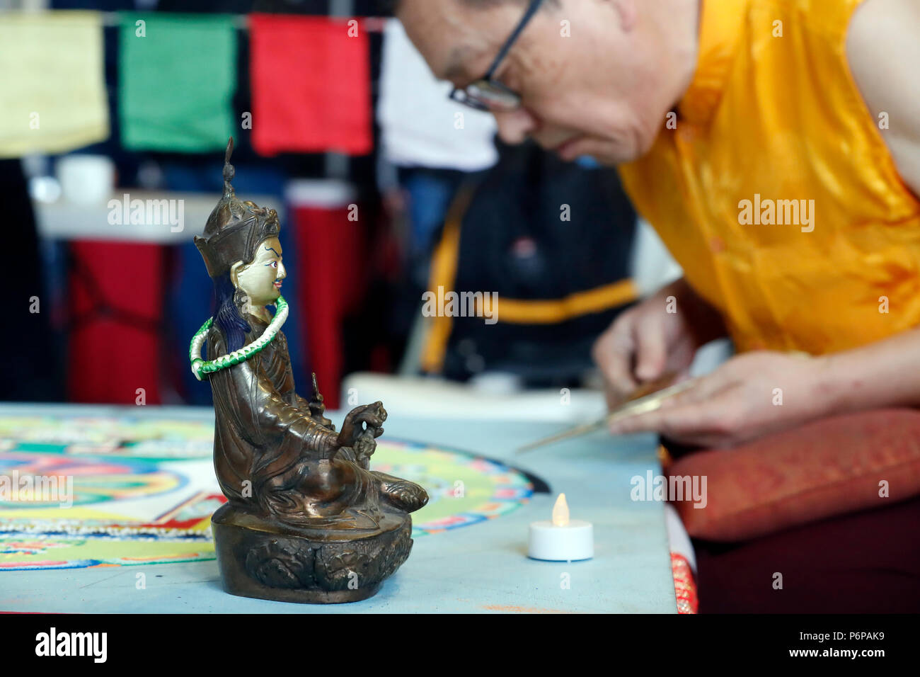 Tibetischen Mönch arbeitet sorgfältig auf einem bunten Sand Mandala. Stockfoto