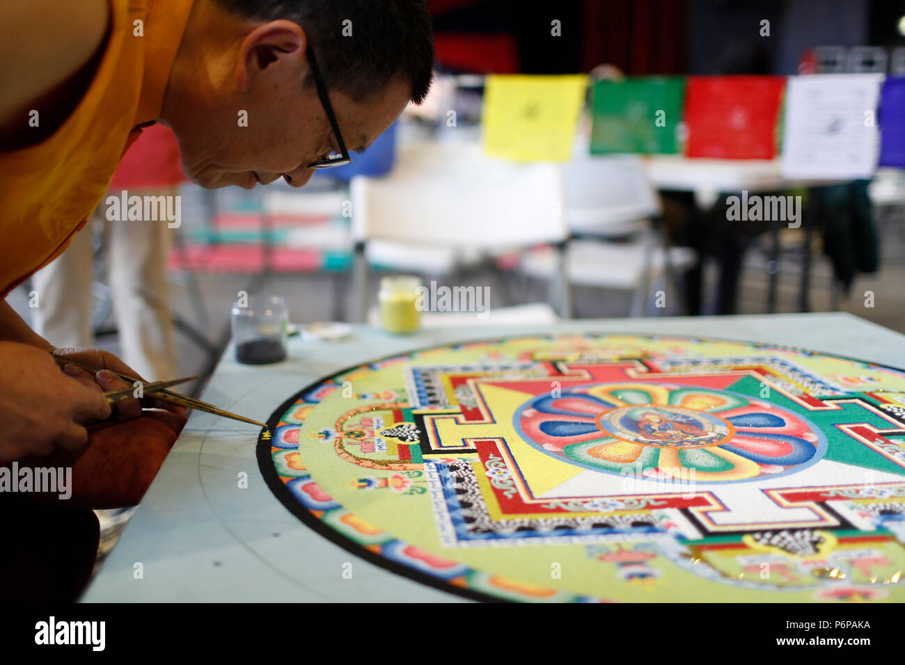 Tibetischen Mönch arbeitet sorgfältig auf einem bunten Sand Mandala. Stockfoto