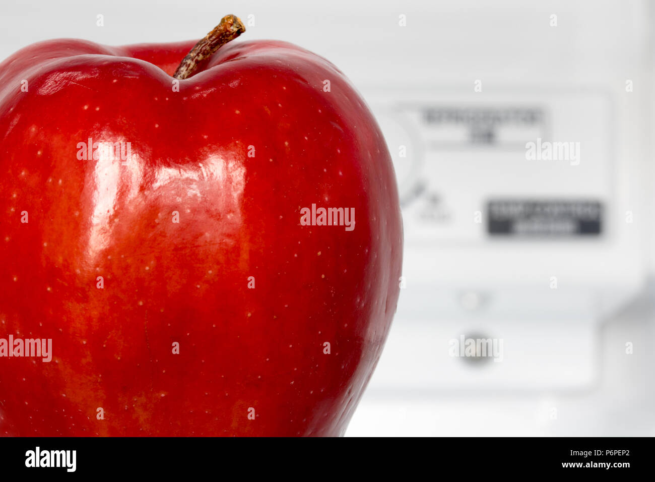 Ein roter Apfel in einem Kühlschrank mit Temperaturregelung im Hintergrund.  Einen frischen Apfel in einem Kühlschrank. Obst ist die Kühlung bei der  Lagerung Stockfotografie - Alamy