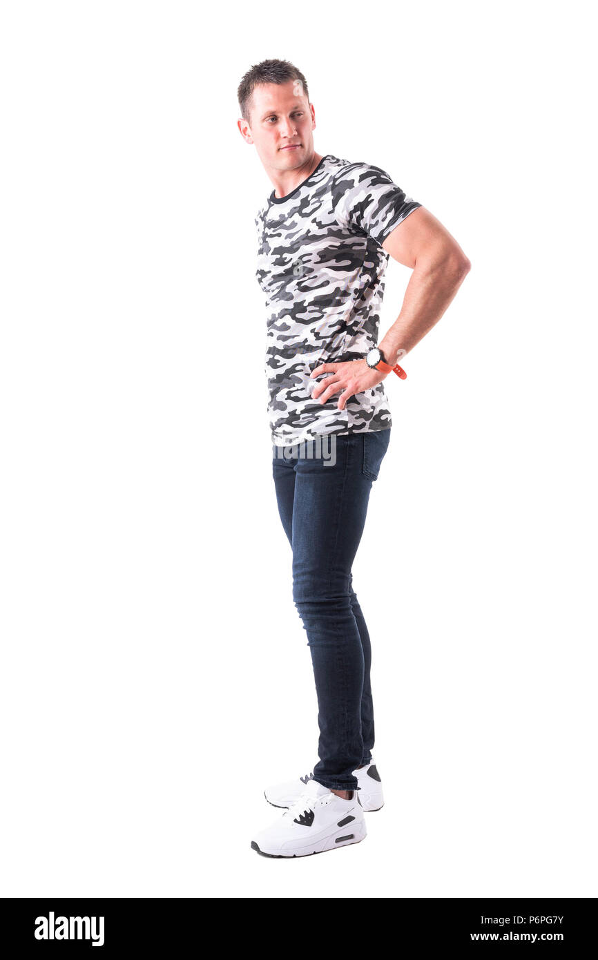 Seitenansicht der coole Macho in der Armee t-shirt stehen und der Blick zurück über die Schulter. Voller Körper auf weißem Hintergrund. Stockfoto