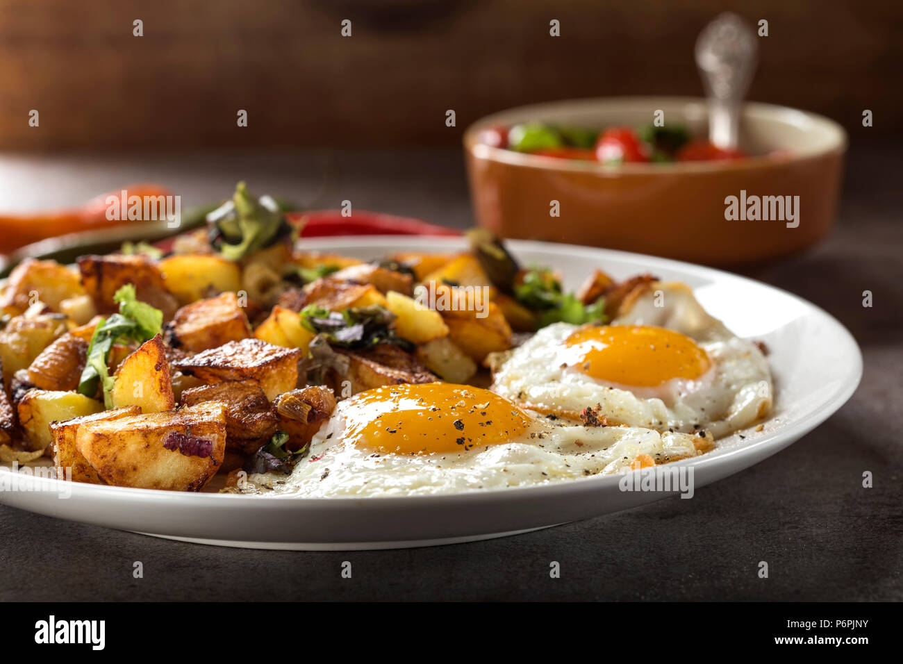 Eier und Pommes Frites mit kleinen Stücken des fettes Schwein Fleisch, Zwiebel und Knoblauch auf Platte Stockfoto