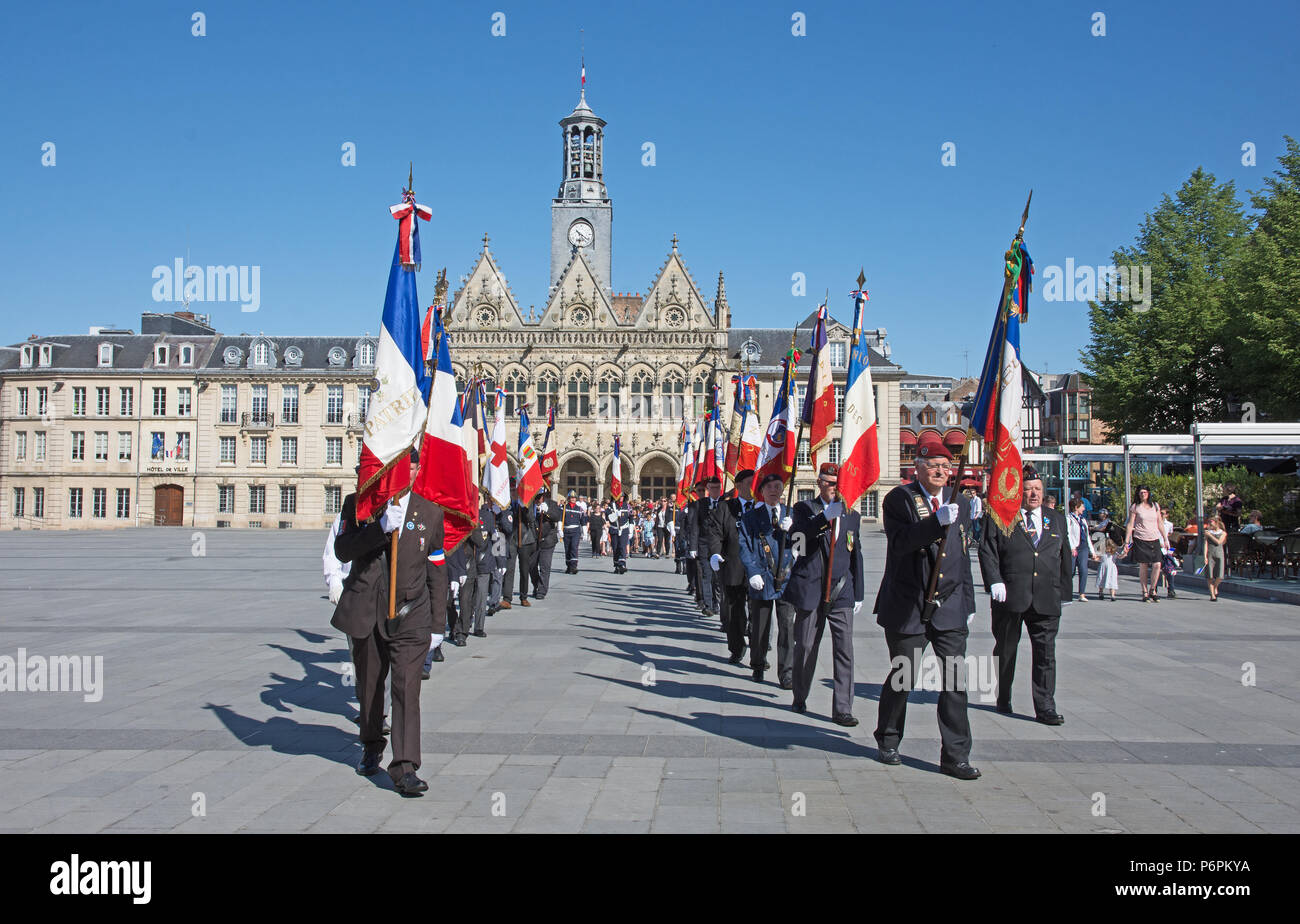 Männer marschieren mit erhobenen Bannern und Flaggen für Sieg in Europa VE Tag 8.Mai 2018 in Place de l'Hotel de Ville St Quentin, Aisne, Frankreich. Stockfoto