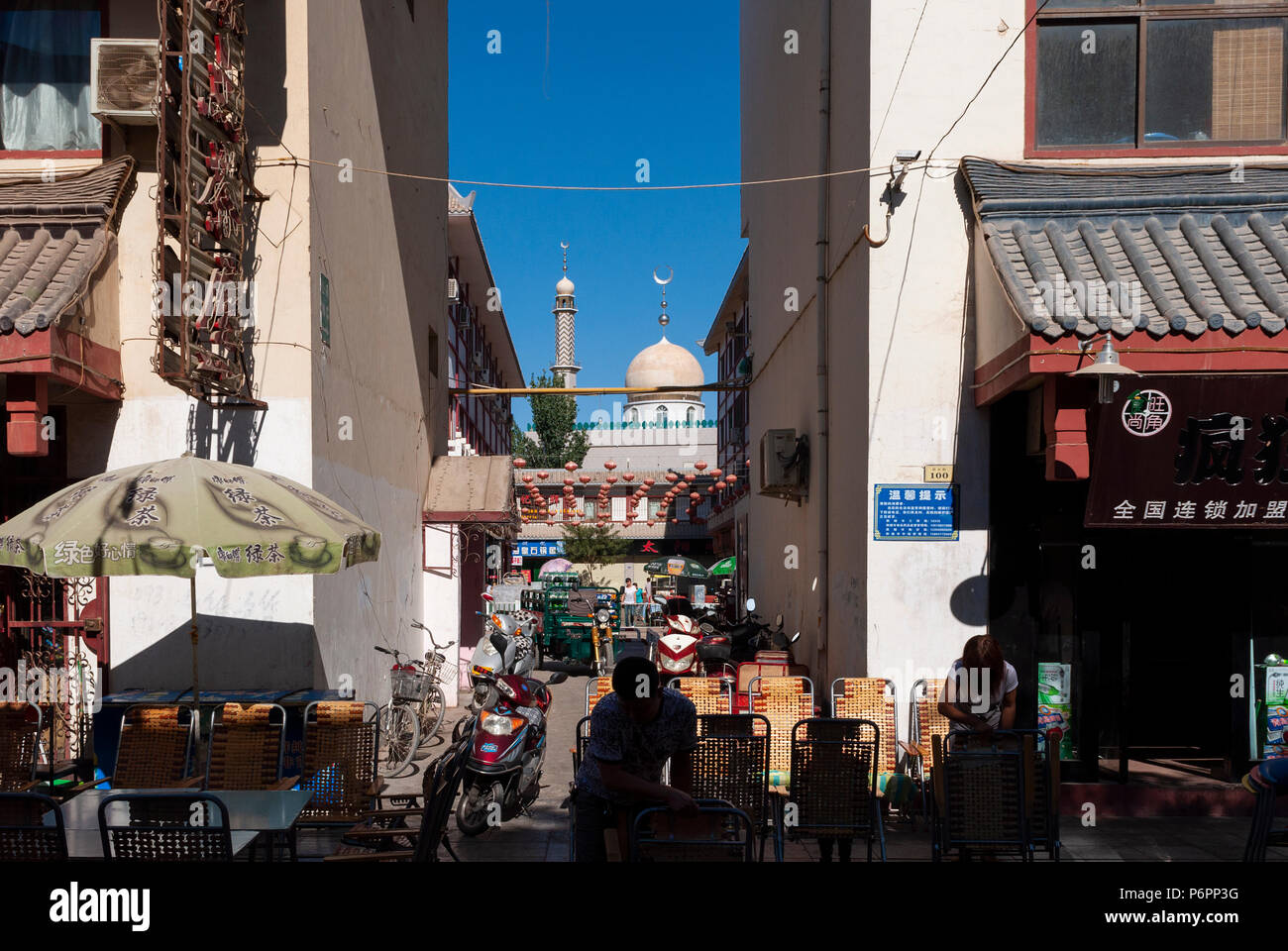 Dunhuang, China - August 7, 2012: Street Scene in der Stadt Dunhuang, mit Menschen auf der Straße und eine Moschee auf dem Hintergrund, in China Stockfoto