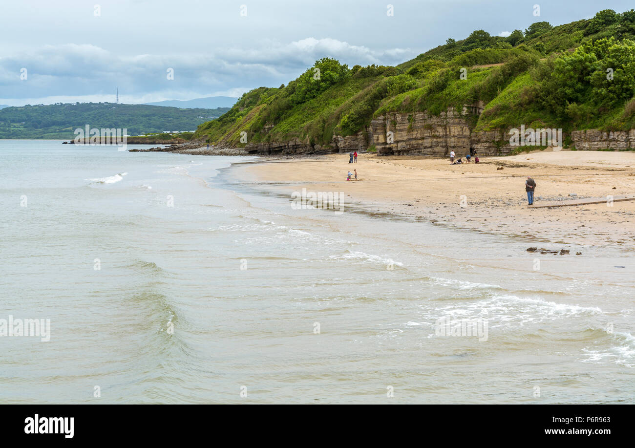 Menschen zu Fuß am Strand von Benllech auf der Insel Anglesey Stockfoto