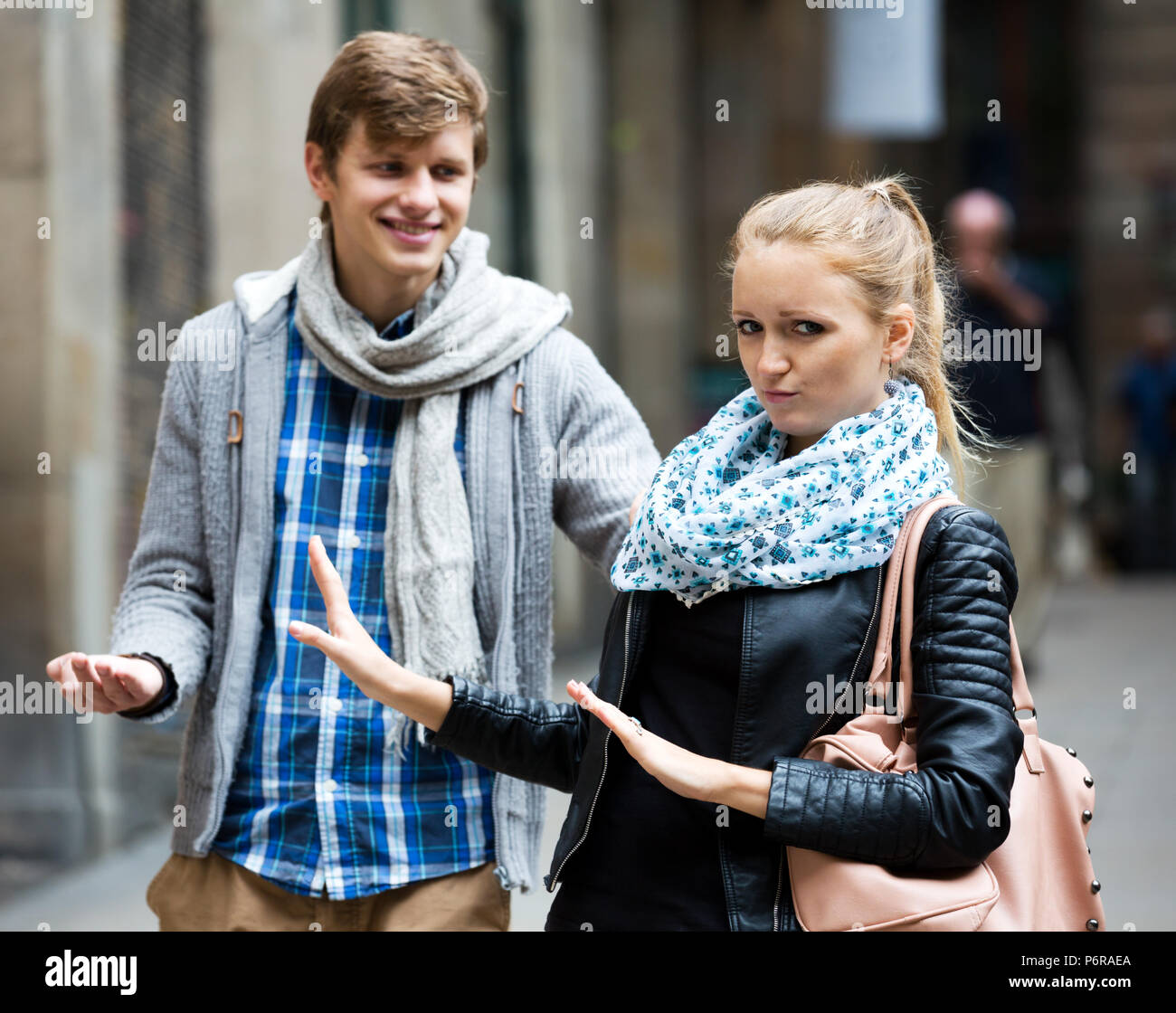 Unglücklich blond nicht loswerden aus stört Verehrer im Freien. Konzentrieren Sie sich auf die Frau Stockfoto