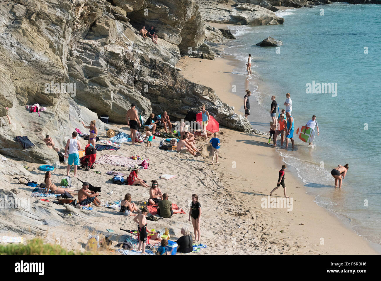 Urlauber genießen das sonnige Wetter mit wenig Fistral in Newquay in Cornwall. Stockfoto