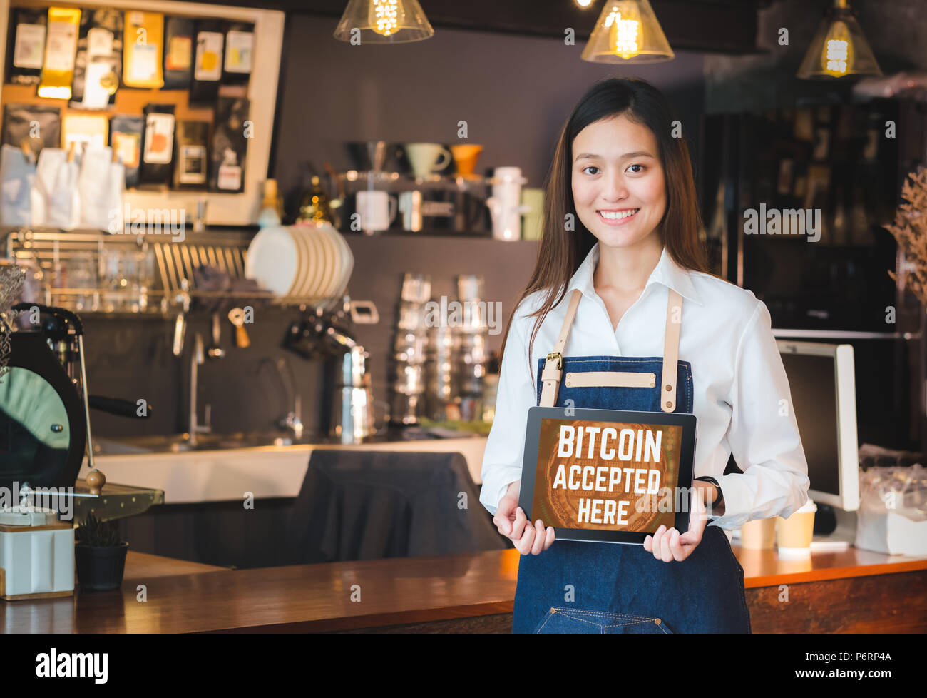 Close up Frau barista Holding Tablet und zeigen Bitcoin hier auf Tablet  Bildschirm im Cafe Bar akzeptiert, Verkäufer Coffee Shop akzeptieren  Zahlungen mit Crypto Stockfotografie - Alamy