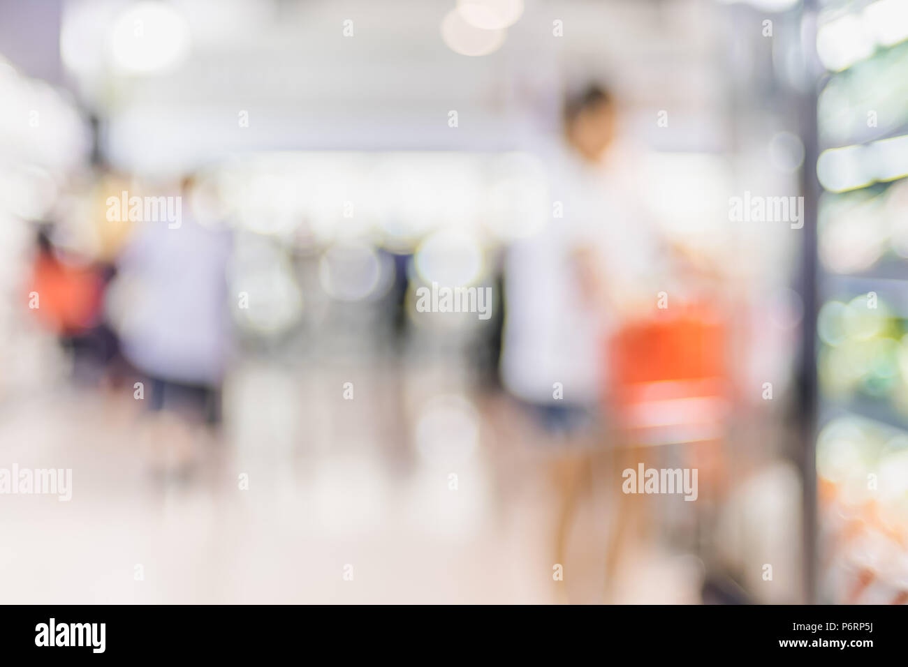 Blur Hintergrund der Kunde einkaufen mit Warenkorb im Supermarkt store Produkt Regal mit bokeh Licht Stockfoto