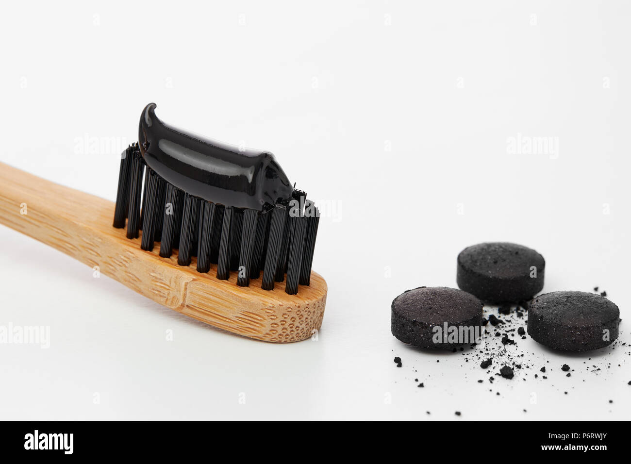 Zahnbürste mit Black Charcoal Zahnpasta. Schwarze Zahnpasta auf eine  Zahnbürste mit Aktivkohle Pillen Stockfotografie - Alamy