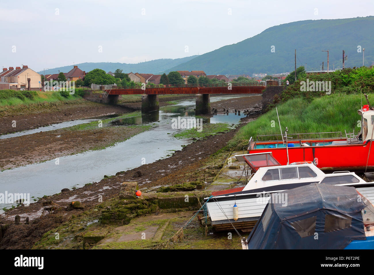 Ein sehr rostig korrodierte Stahl Brücke überspannt einen Tidal River mit allen Panels sichtbar seriouslly durch Korrosion durchlöchert, eingezäunt für Sicherheit reaso. Stockfoto