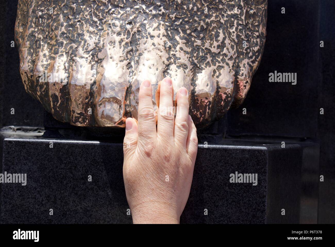 Woman's Hand auf Statue Stockfoto