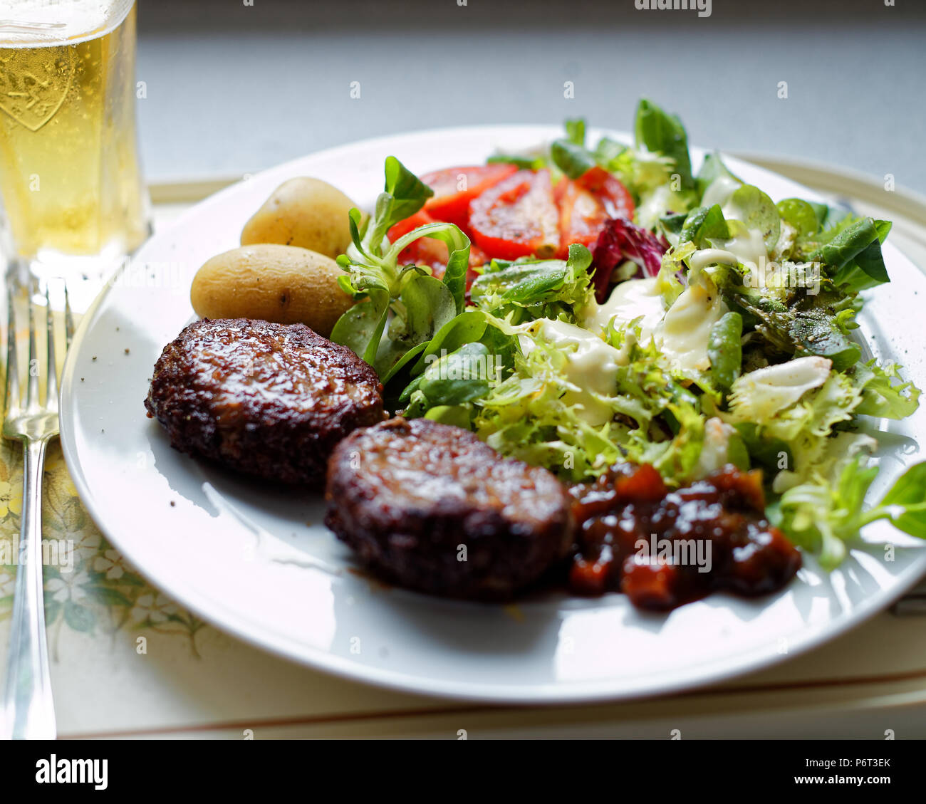 Burger Salat, plus Lager. Stockfoto