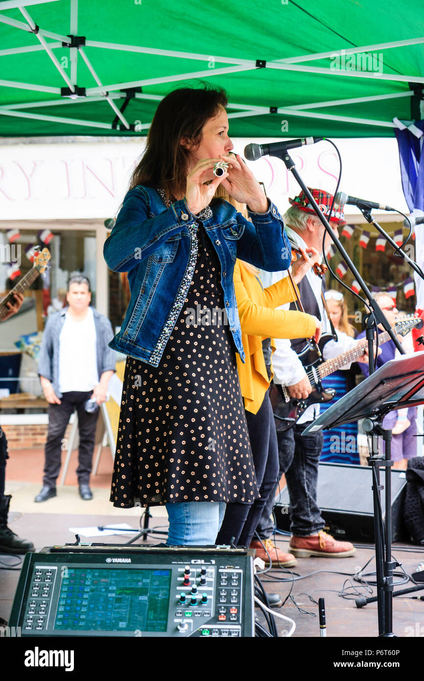 Kaukasische Frau spielen Flöte in Open Air Konzert. Karine Magnier stehend mit der französischen Band folk rock Triskelles am Sandwich Stadt, England. Stockfoto