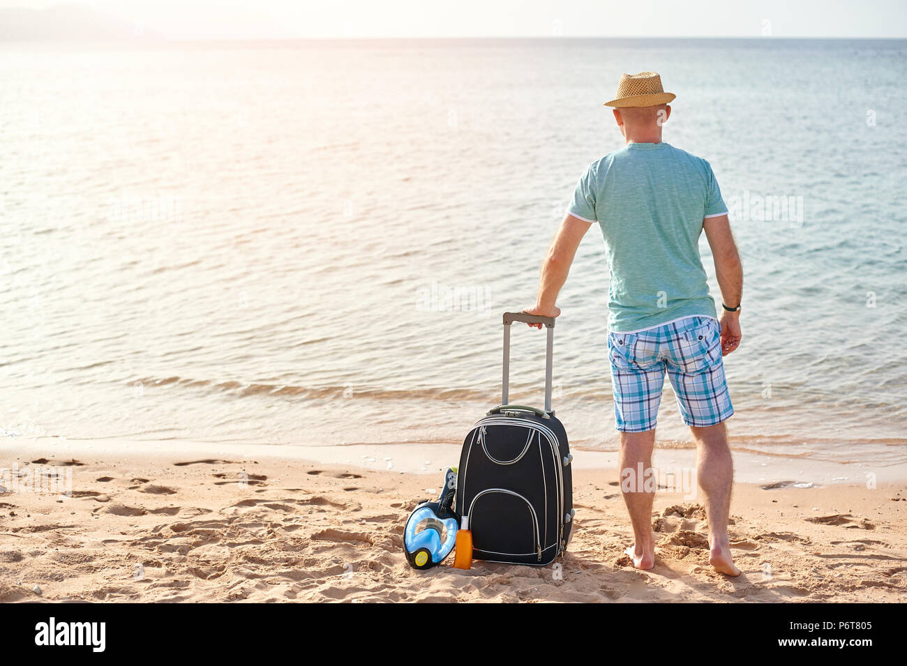 Man Touristen im Sommer Kleidung mit einem Koffer in der Hand, am Meer am Strand suchen, Vorstellung von Zeit zu reisen Stockfoto Man Touristen im Sommer Kleidung mit einem Koffer in der Hand, am Meer am Strand suchen, Vorstellung von Zeit zu reisen Stockfoto