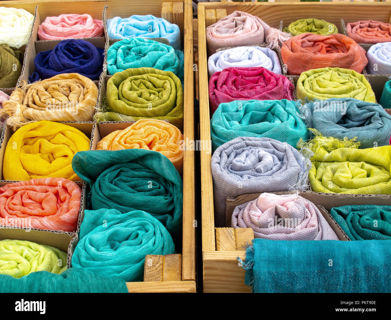 Tücher in verschiedenen Farben zusammengerollt auf der Verkaufstheke Stockfoto