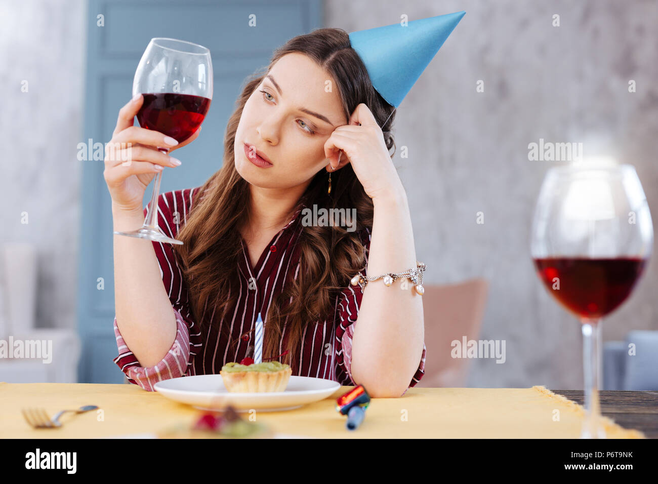 Pessimistisch dunkelhaarige Frau an Glas Wein suchen Stockfoto