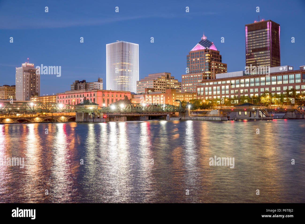 Rochester, New York: eine Skyline der Stadt in der Dämmerung entlang der Genesee River. Stockfoto