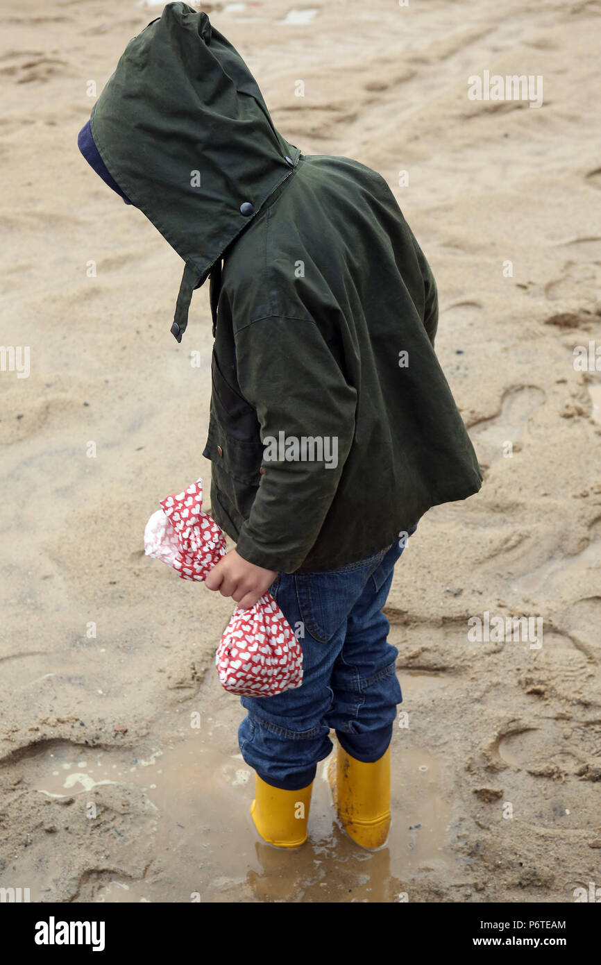 Hamburg, Kind mit Regenjacke und Gummistiefel in einer Pfuetze Stockfoto