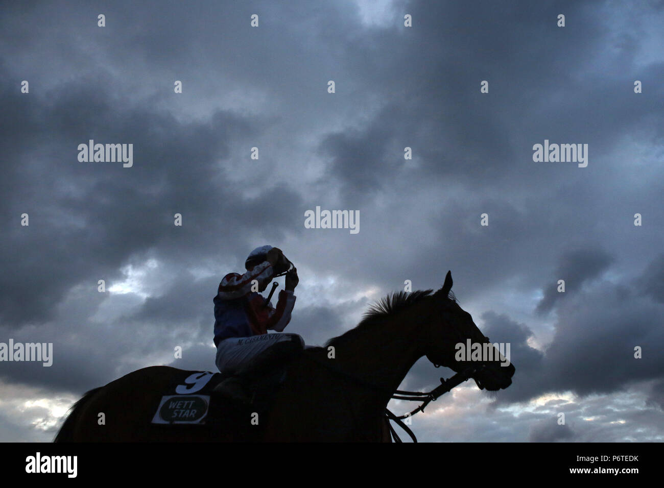 Hamburg, Silhouette, Pferd und Jockey vor dunklen Gewitterwolken Stockfoto