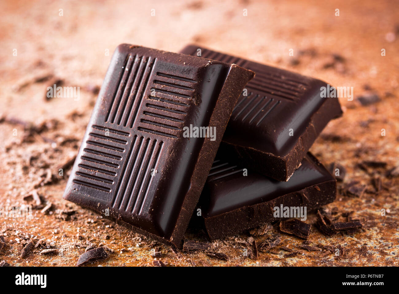 Schwarze Schokolade Stücke auf braunen Hintergrund. Stockfoto
