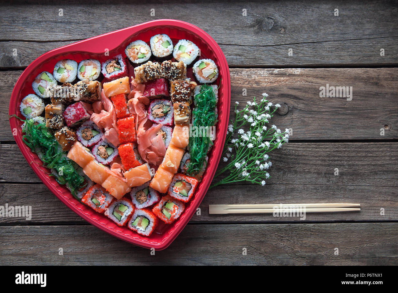 Sushi auf einem alten Holztisch Hintergrund mit einem Herzförmigen Dekor Stockfoto