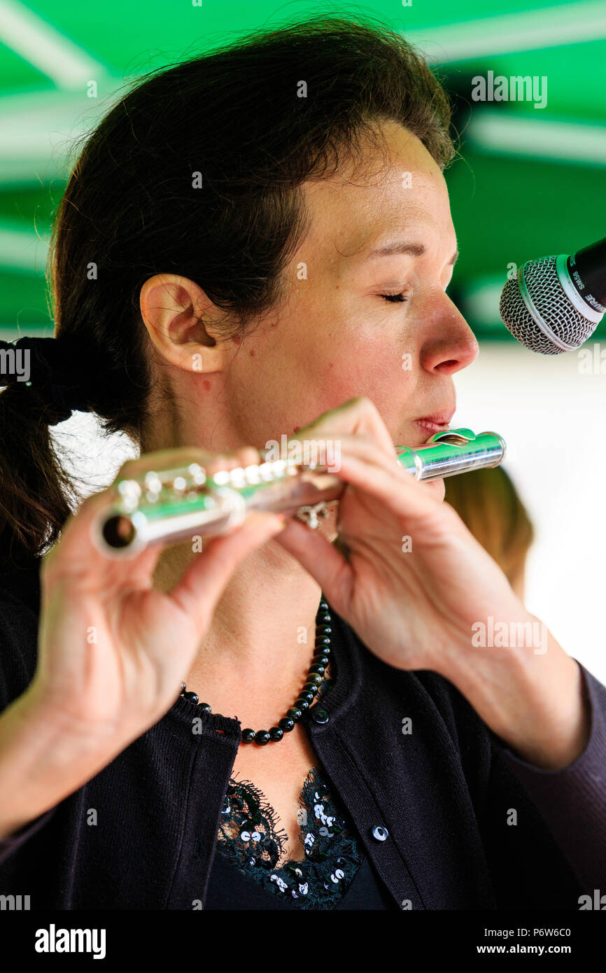 Kaukasische Frau spielen Flöte in Open Air Konzert. Karine Magnier stehend mit der französischen Band folk rock Triskelles. Nahaufnahme des Gesichts. Stockfoto