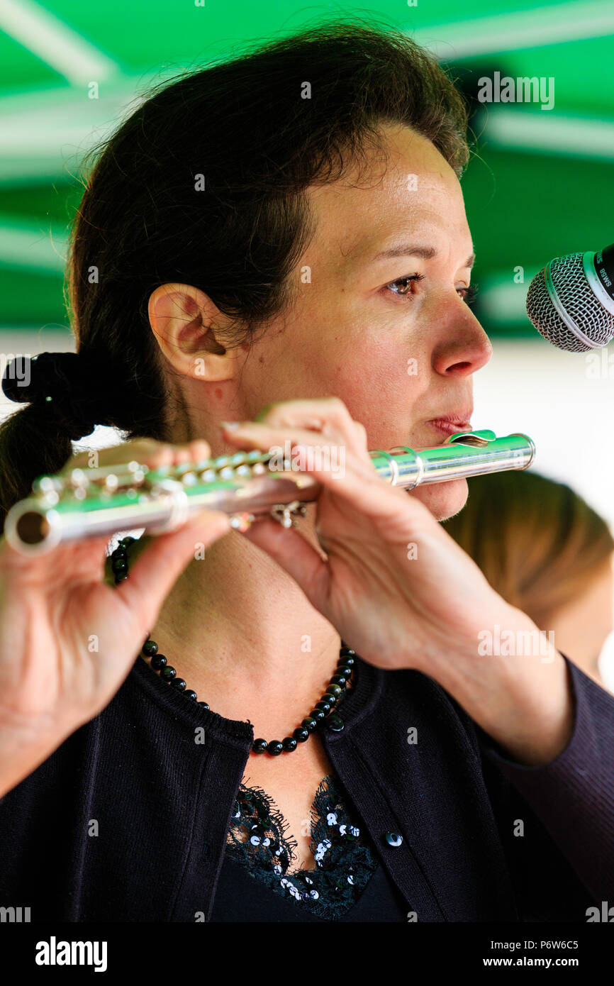 Kaukasische Frau spielen Flöte in Open Air Konzert. Karine Magnier stehend mit der französischen Band folk rock Triskelles. Nahaufnahme des Gesichts. Stockfoto