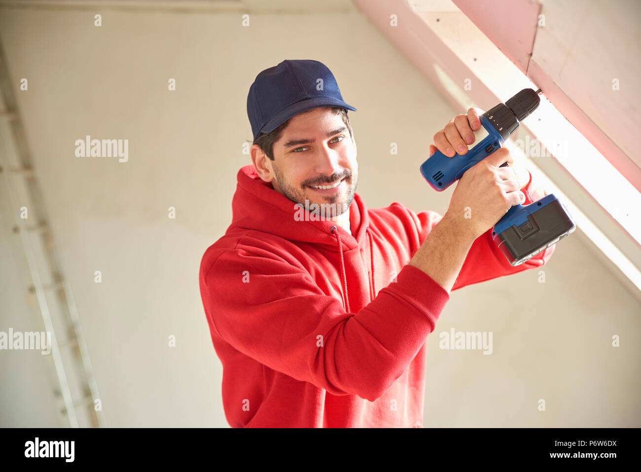 Porträt der jungen Handwerker mit dem Hammer Drill Fahrer auf der Baustelle. Stockfoto