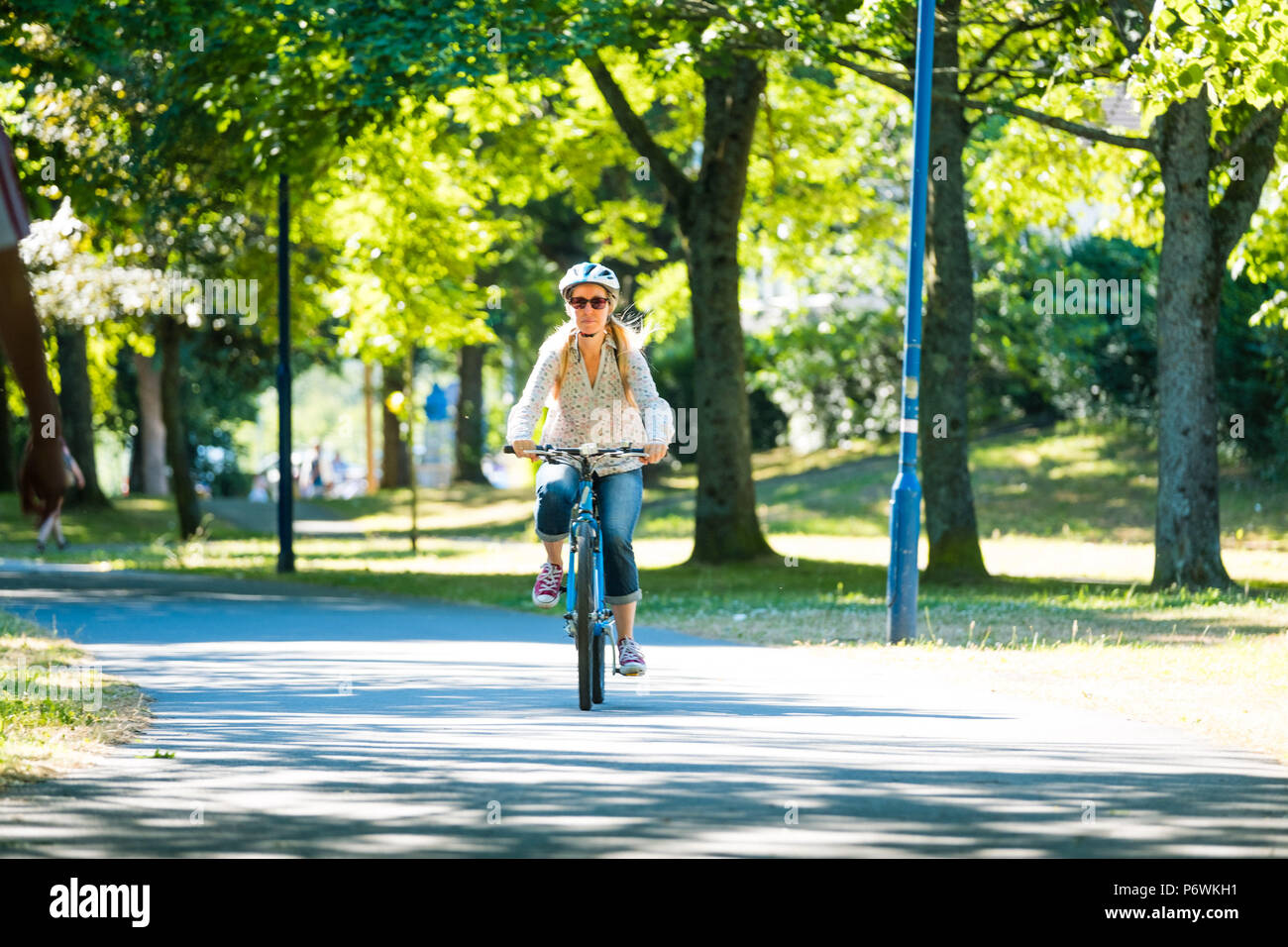 Aberystwyth, Wales, UK. 3. Juli 2018. UK Wetter: eine Frau Radfahren in Plas Crug Park auf einem anderen warmen und sonnigen Morgen in Aberystwyth Wales. Die längere extreme Hitze und sehr trockene Wetter Prognose für weitere zwei Wochen, um der Bedrohung durch Dürre und Wasserknappheit in einigen Bereichen. Photo Credit: Keith Morris/Alamy leben Nachrichten Stockfoto