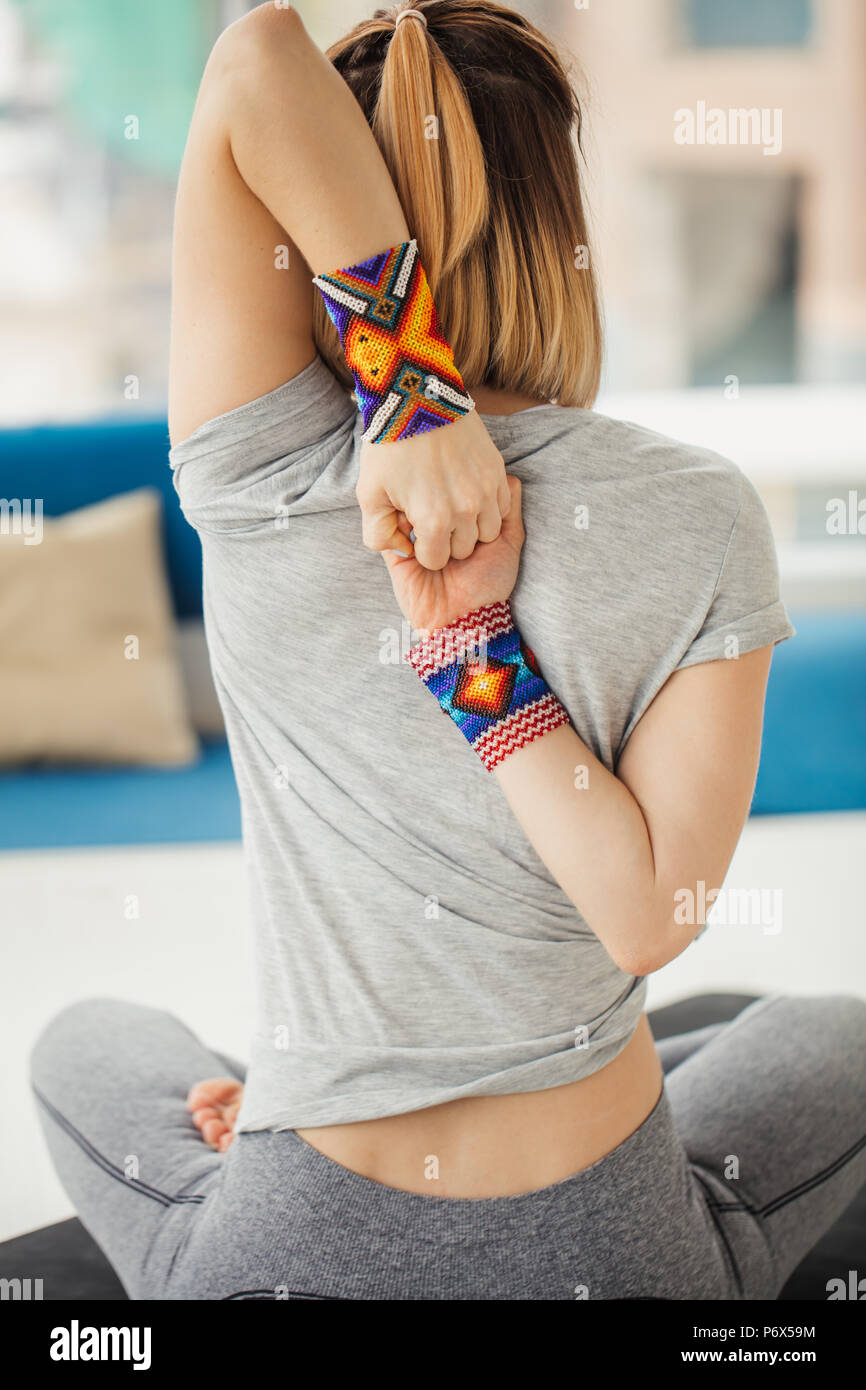 In der Nähe der weiblichen Händen mit Armbänder hinter dem Rücken, Frau Üben Yoga, im Cow Gesicht Übung sitzen, Gomukasana darstellen, arbeiten, tragen w Stockfoto