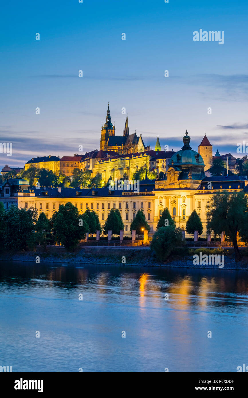 Tschechische Republik, Prag. Prager Burg (Prazsky Hrad) und Straka Akademie (Strakova Akademie) der Sitz der Regierung der Tschechischen Republik, an der Moldau in der Abenddämmerung. Stockfoto