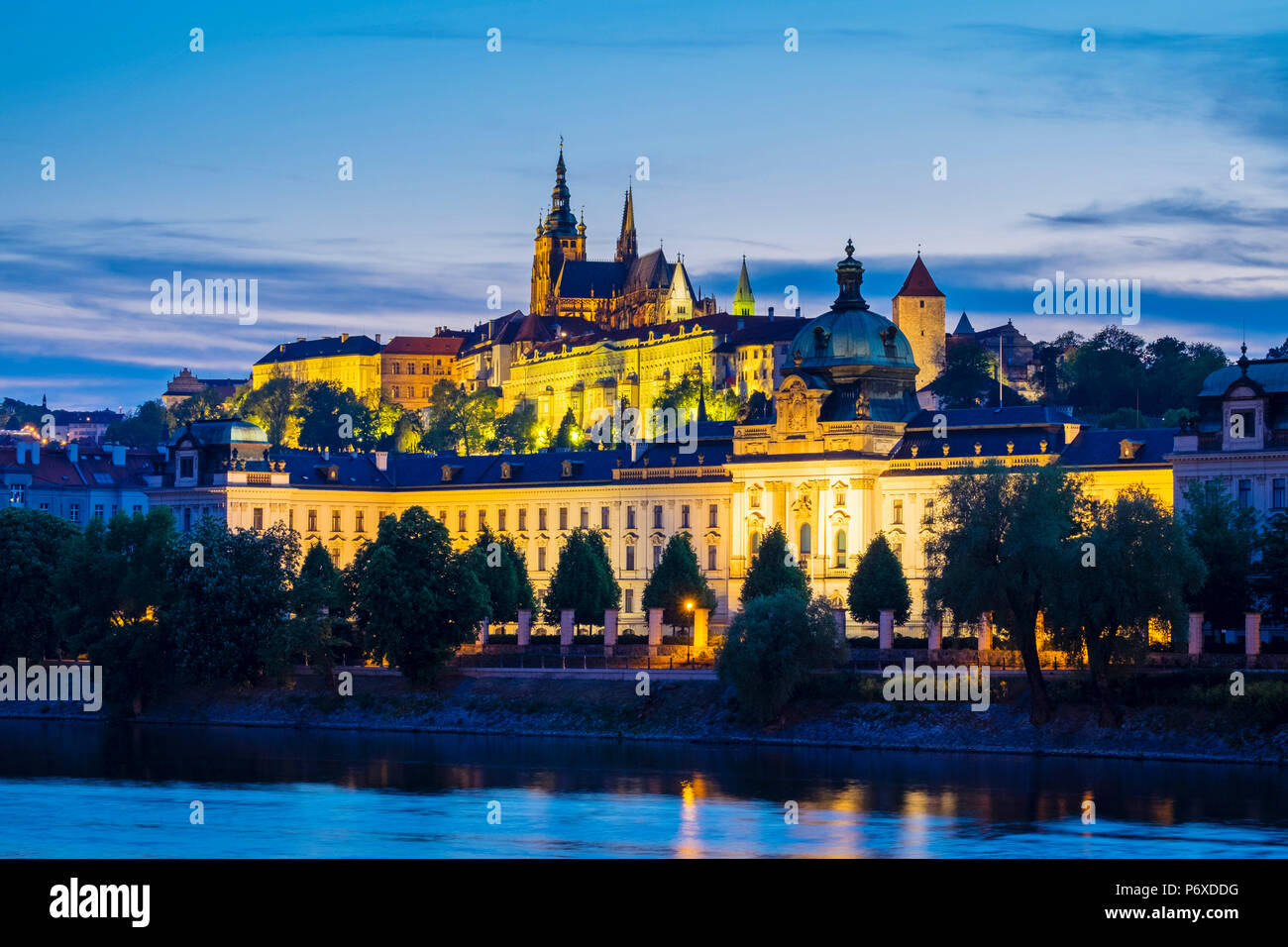 Tschechische Republik, Prag. Prager Burg (Prazsky Hrad) und Straka Akademie (Strakova Akademie) der Sitz der Regierung der Tschechischen Republik, an der Moldau in der Abenddämmerung. Stockfoto