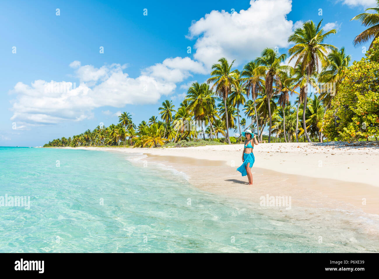 Canto de la Playa, Saona, East National Park (Parque Nacional del Este), Dominikanische Republik, Karibik. Schöne Frau auf einer von Palmen gesäumten Strand (MR). Stockfoto