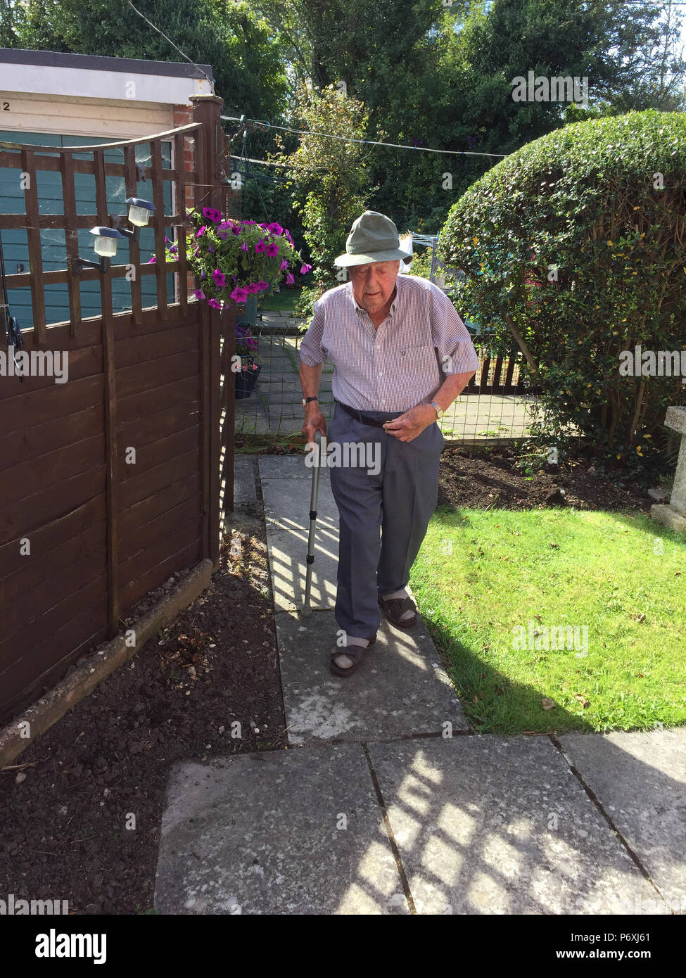 Älterer Mann entlang Gartenweg Stockfoto