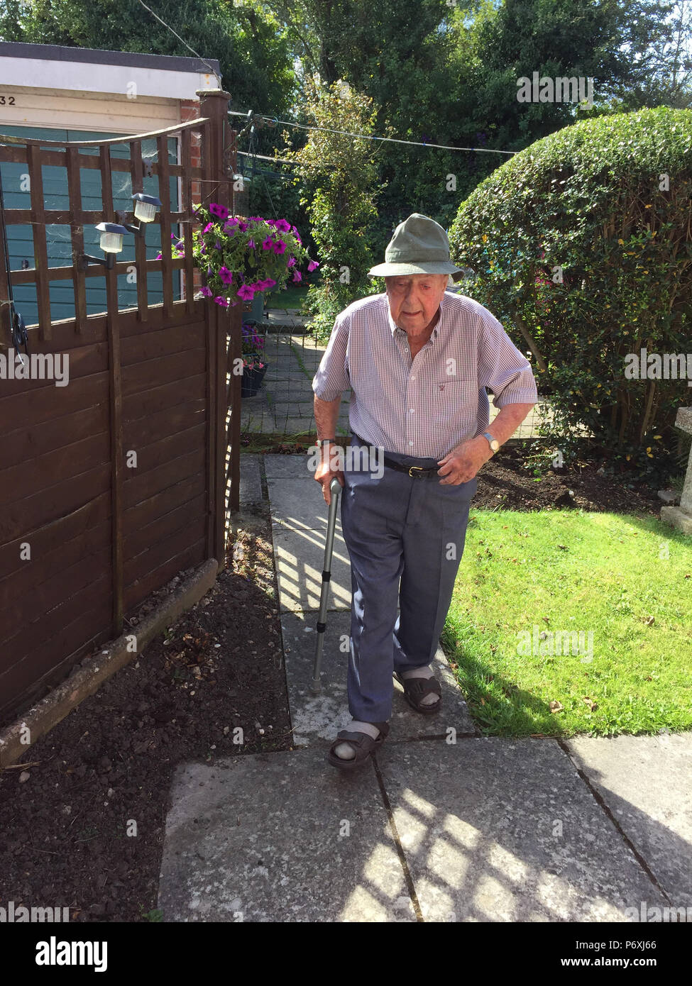 Älterer Mann entlang Gartenweg Stockfoto