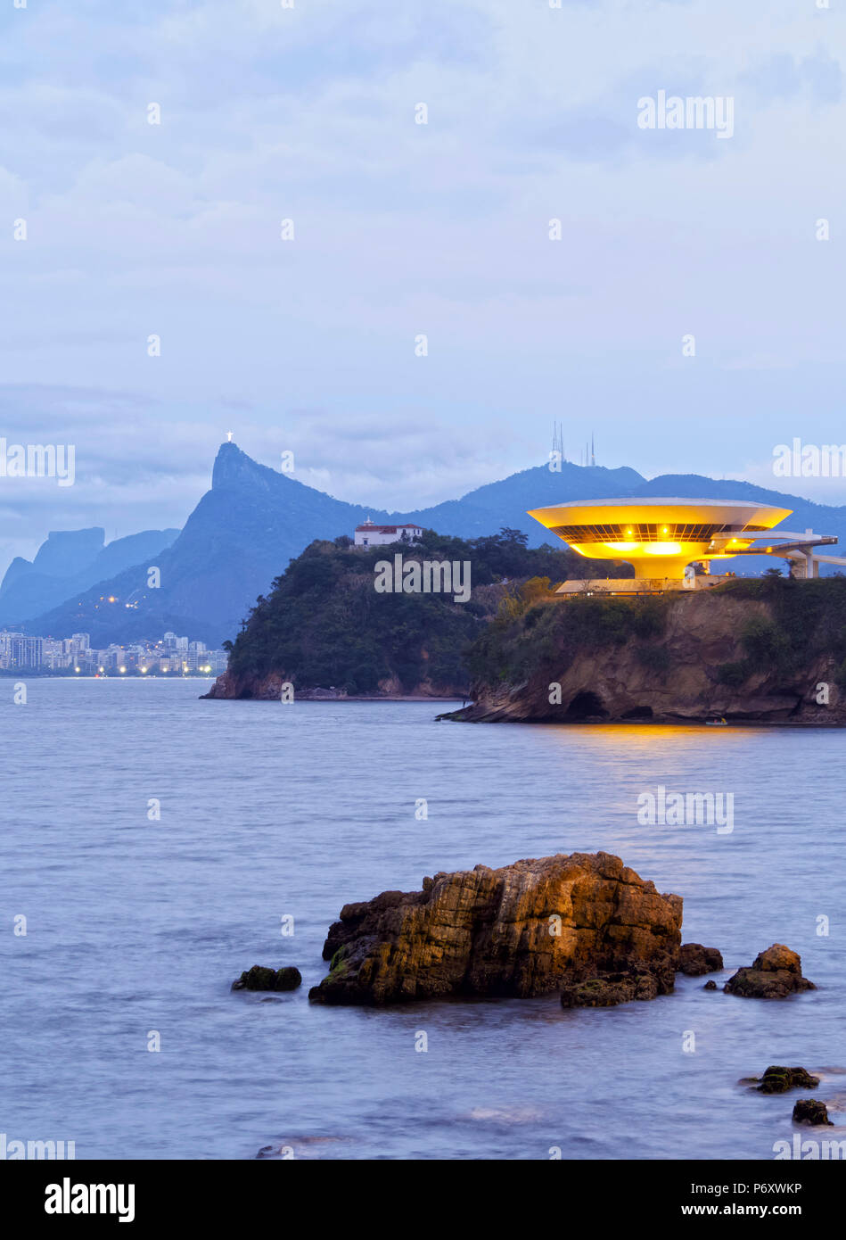 Brasilien, Bundesstaat Rio de Janeiro, Niteroi, Dämmerung Blick auf die niteroi Museum für Zeitgenössische Kunst mit Skyline von Rio de Janeiro im Hintergrund. Stockfoto