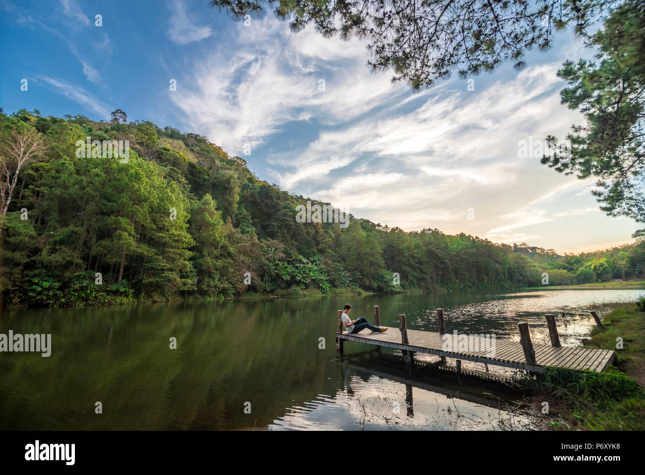 Mann mit Tablette ist in Pang Ung See, im Norden von Thailand ist ein touristischer Ort, wo Leute Urlaub im Winter kommen Stockfoto