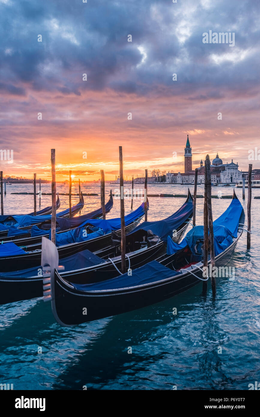 Venedig, Venetien, Italien. Gondeln vertäut am Riva degli Schiavoni bei Sonnenaufgang. Stockfoto