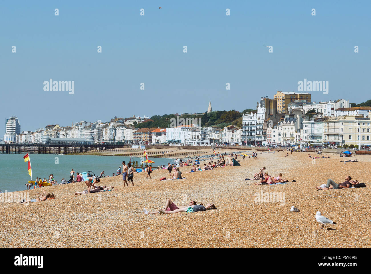 Sonnenanbeter am Strand von Hastings, East Sussex, UK im Juni Stockfoto