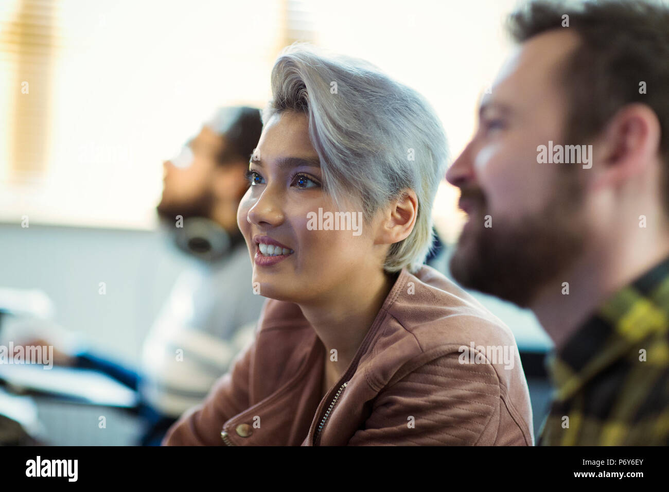 Lächelnd kreativen Geschäftsfrau hören in Sitzung Stockfoto