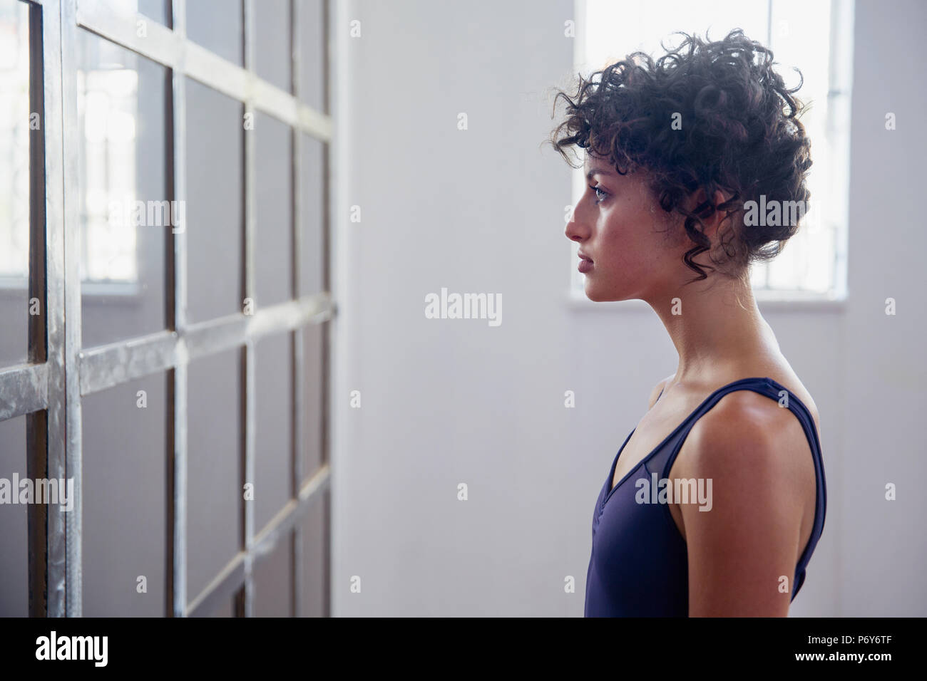 Profil ernsthafte junge Tänzerin bei Spiegel im Tanz Studio Stockfoto