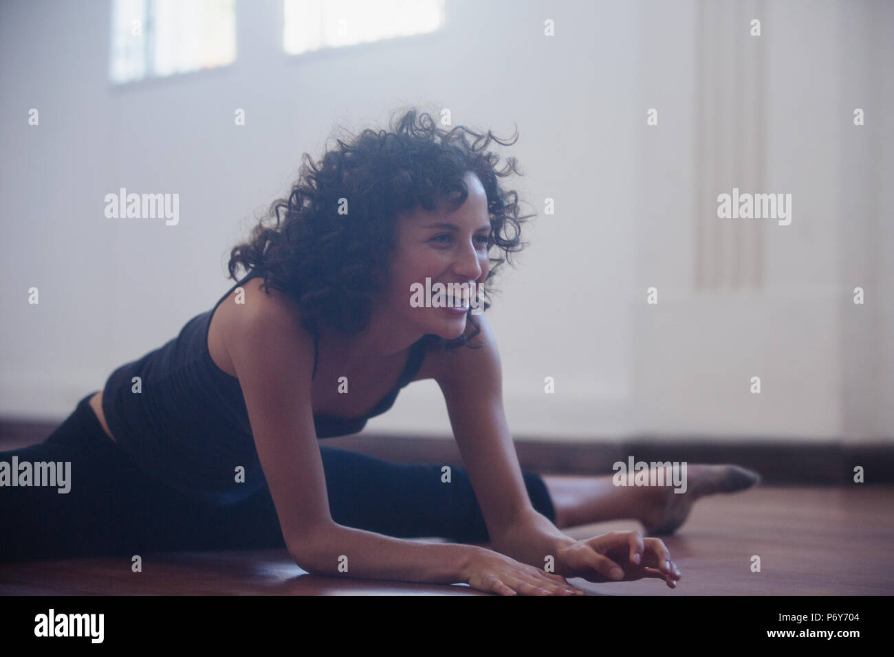 Glückliche, selbstbewusste junge Tänzerin Stretching im Tanz Studio Stockfoto