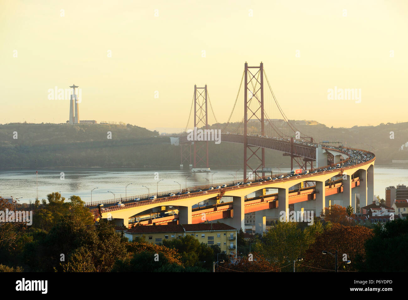 25 de April Brücke (ähnlich der Golden Gate Bridge) über den Fluss Tejo und die Cristo Rei (Christus König) am Südufer des Flusses, am Abend. Lissabon, Portugal Stockfoto