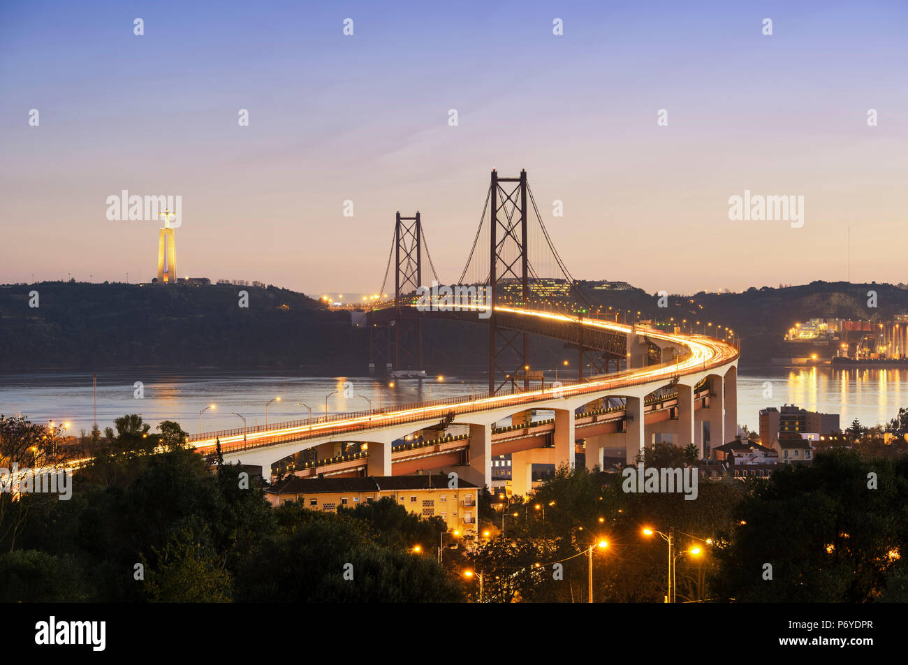 25 de April Brücke (ähnlich der Golden Gate Bridge) über den Fluss Tejo und die Cristo Rei (Christus König) am Südufer des Flusses, am Abend. Lissabon, Portugal Stockfoto