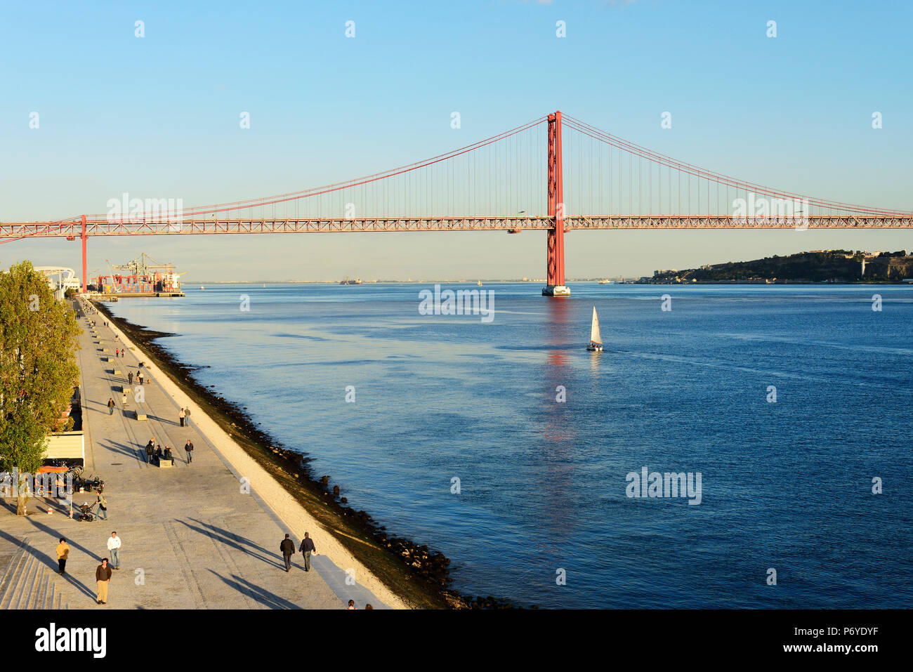 Belem Esplanade, entlang den Fluss Tagus. 25 de Abril Brücke im Hintergrund. Lissabon, Portugal Stockfoto
