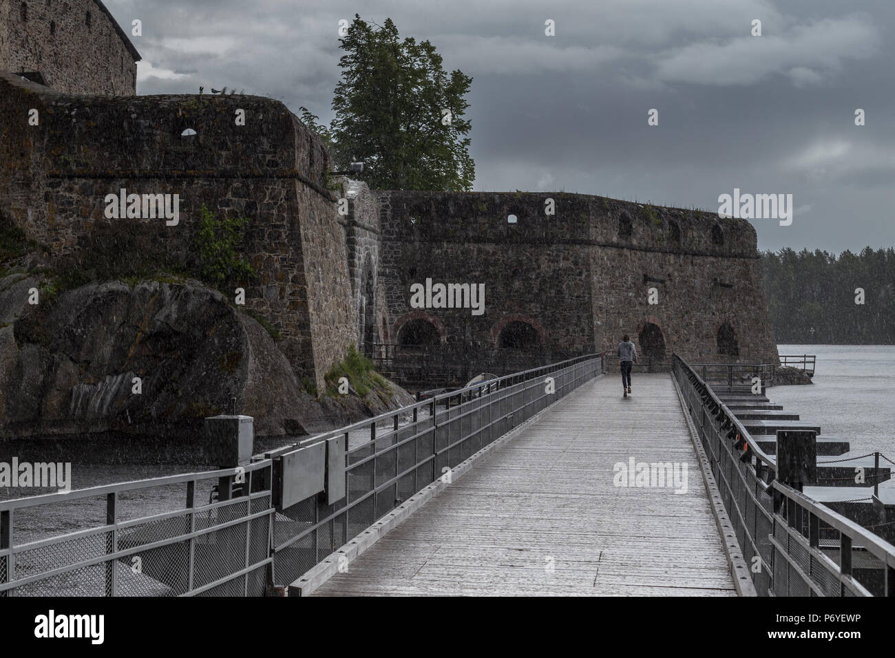 Person in Richtung mittelalterliche Burg im Regen Stockfoto