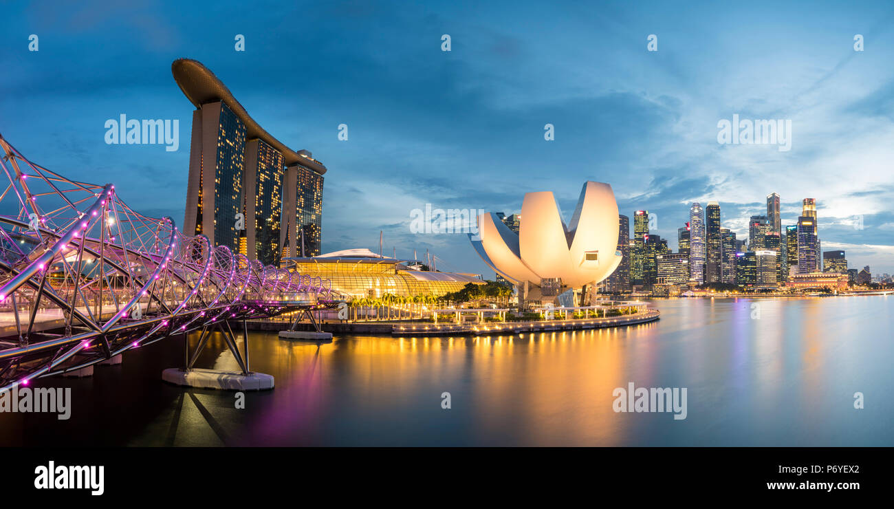Singapur, Republik Singapur, Südostasien. Panoramablick auf den Helix Bridge, Marina Bay Sands und der ArtScience Museum in der Abenddämmerung. Stockfoto