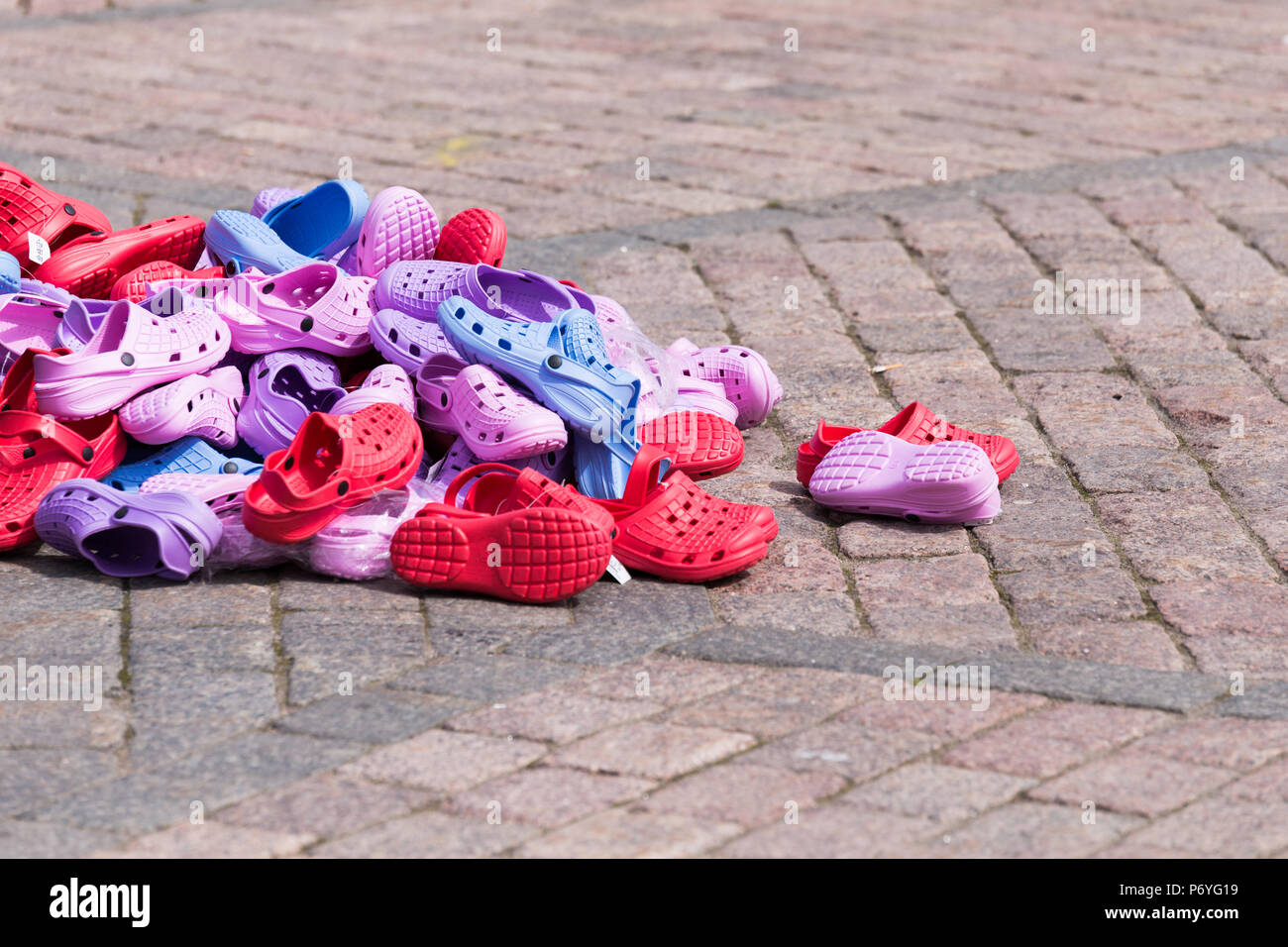 Über Stapel der anderen Farbe Kunststoff Schuhe auf Pflaster klopfte Stockfoto